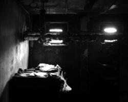 Black and white shot of desolate workplace in the basement with lots of paperwork photo