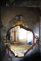 Burst, bent door with sign Heizraum - Unbefugten ist der Zutritt verboten Boiler room - Off limits to unauthorized personnel photo