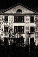 Black and white shot of haunted villa and starry sky photo