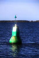 Green buoy in the Baltic Sea reflecting bright sunlight photo