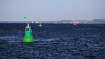 Green buoy in the Baltic Sea in sunlight photo