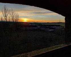 View from old window over a rural landscape in sunset photo