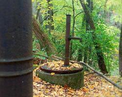 Rusty abandoned pumps on a disused well in the wilderness photo
