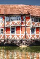 A historic half-timbered house over a small canal in Wismar, Germany photo