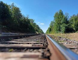 Looking closely over a straight rural railway track photo