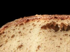 Closeup of a cut sourdough bread on black background photo