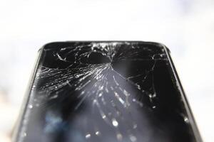 Macro of phone with broken display with white background photo