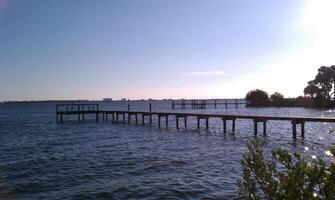 A pier with a boat on it and a bridge photo