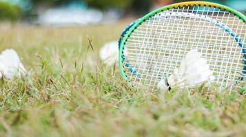 A badminton racket and shuttlecock resting on a grassy field, symbolizing the joy of outdoor sports, healthy living, and the importance of recreational activities to build fitness and bonds. photo