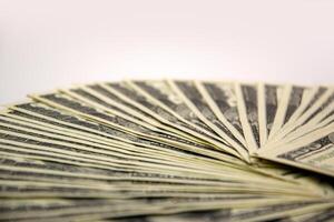 A close-up view of a fan of US dollar bills arranged on a white surface photo