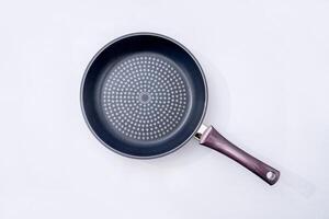 Top view of new empty frying pan isolated on white photo