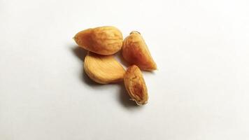 Garlic that turns into golden garlic has a slightly transparent golden yellow color, with a soft texture that tends to be sticky. Golden garlic isolated on white background. photo