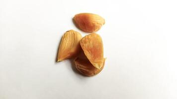 Garlic that turns into golden garlic has a slightly transparent golden yellow color, with a soft texture that tends to be sticky. Golden garlic isolated on white background. photo