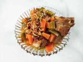 Asem-asem Daging or Vegetable Sour Beef Soup is typical dish of Java, Indonesia. With beef, carrot and beans as ingredients plus Javanesse starfruit. photo