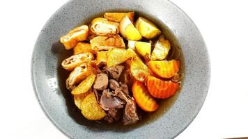 Timlo is a soup, containing sliced chicken gizzard liver, sliced rolled omellete, sliced solo sausage, vermicelli, boiled egg and shredded fried chicken. photo