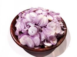 Sliced red onion on a ground plate on a white background photo