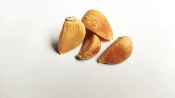 Garlic that turns into golden garlic has a slightly transparent golden yellow color, with a soft texture that tends to be sticky. Golden garlic isolated on white background. photo