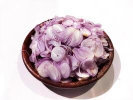 Sliced red onion on a ground plate on a white background photo