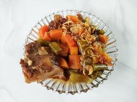Asem-asem Daging or Vegetable Sour Beef Soup is typical dish of Java, Indonesia. With beef, carrot and beans as ingredients plus Javanesse starfruit. photo