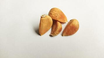 Garlic that turns into golden garlic has a slightly transparent golden yellow color, with a soft texture that tends to be sticky. Golden garlic isolated on white background. photo