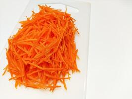 View of juice sliced carrots. Julienne carrot in a white plate. Copy space. photo