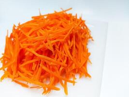 View of juice sliced carrots. Julienne carrot in a white plate. Copy space. photo