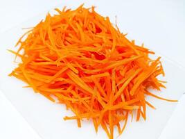 View of juice sliced carrots. Julienne carrot in a white plate. Copy space. photo