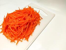 View of juice sliced carrots. Julienne carrot in a white plate. Copy space. photo