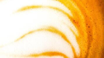 High-angle full-frame shot of coffee and milk swirling together, featuring frothy foam bubbles and creating a captivating abstract pattern. photo