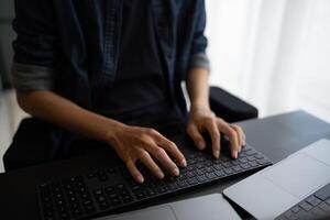 Asian man software engineer Working on Computer at office desk for writing program code IT Software Engineer finding errors tech support devops creating digital photo