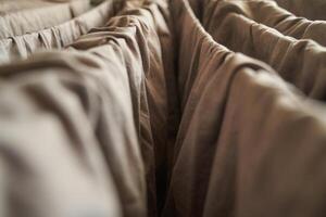 Close up of brown fabric folds creating abstract pattern with soft lighting. photo