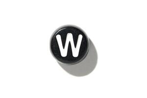 Vintage typewriter key w on white background with dramatic shadow and minimalistic design photo