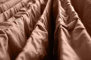 Close up view of beige folded fabric with textured layers and soft creases in ambient lighting. photo