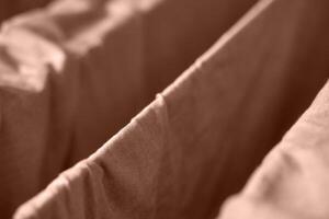Close up view of brown fabric folds creating geometric patterns in soft light and gentle texture. photo