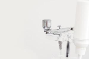 Close up of modern airbrush tool with white background for artistic painting techniques. photo