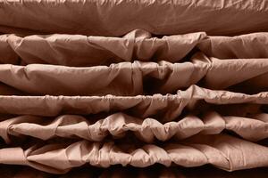 Abstract brown fabric texture with wavy layers and folds creating symmetrical patterns. photo