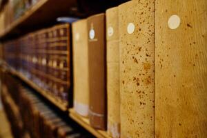 Old books on wooden shelves in library photo