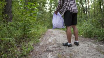 Young man throwing litter garbage from plastic bag on ground. Environmental pollution. Global warming. Male throwing out garbage in forest. Ecological issue. Throw trash anywhere. Contaminated soil. video
