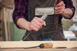 Carpenter working with a chisel photo