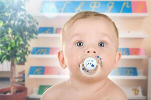 Baby with Pacifier in Bright Classroom Setting photo