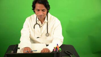 médico sorrisos enquanto digitando relatório em dele computador video