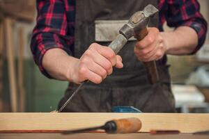 Carpenter working with a chisel photo