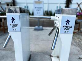Exit turnstile gate with clear signage in Thai, English, and Chinese languages, representing controlled access and public facility management photo