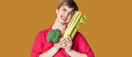 Smiling slender Caucasian girl with green vegetables in her hands, free space. Organic vegetables. photo
