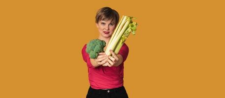 Smiling slender Caucasian girl with green vegetables in her hands, free space. Organic vegetables. photo