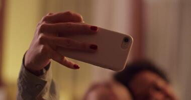 Smiling multiethnic girlfriends taking selfie at home video