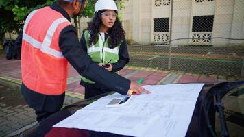 Co workers reviewing building map on a car video