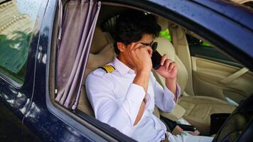 Uniform captain sits in vehicle conversing by call video