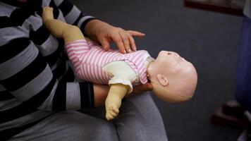 Practicing reanimation of infants. Medic shows tehnique with two fingers. Appropriate methods of first medical help. video