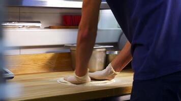 Professional chef kneading floured dough for bread in bakery shop. Man hands are forming the dough on a floured surface video